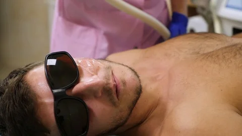 Man getting permanent laser facial hair removal at beauty salon Video stock 102399985