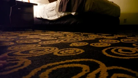 A man getting ready for bed in a hotel room late at night Stock Footage 82510198