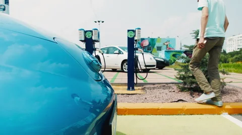 Man getting ready to charge his electric car Stock Footage 66039753