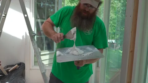 Man getting ready to mud sheetrock in home DIY project Stock Footage 159003438