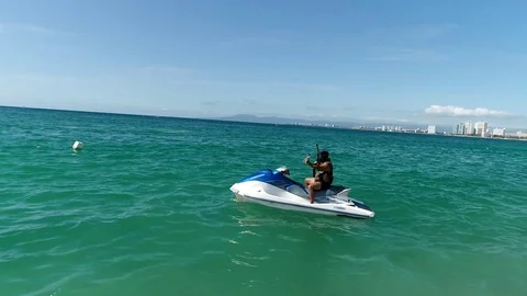A man is getting ready for riding a jet ski and play paintball Stock Footage 123985716
