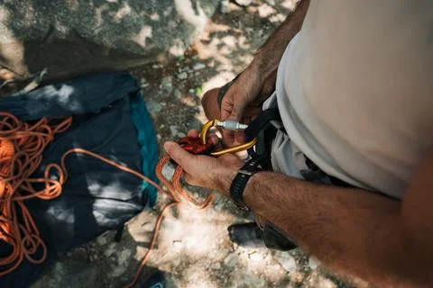 Man getting the rope ready to go outdoor climbing Stock Photos