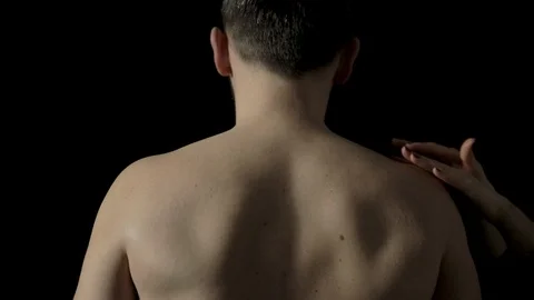 A man getting a sensual upper back massage from female hands as he sits Stock Footage 102839505