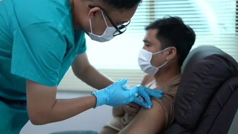 A man is getting a shot from a nurse. Vídeo Stock 291154711