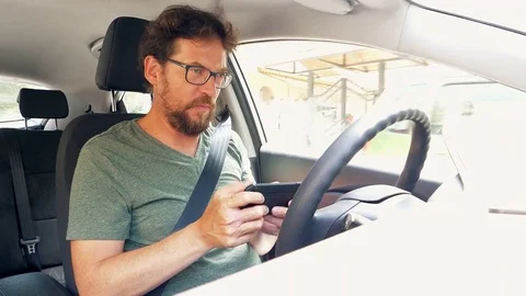Man getting very scared driving car playing with smartphone almost getting in Stock Footage 76678250