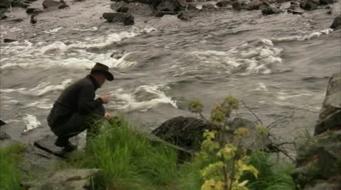 A man getting water from a river Stock Footage 11315481