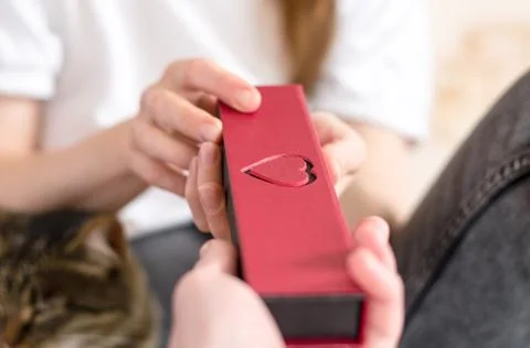 A man gives a gift to his beloved woman, close-up, selective focus. Gift box Stock Photos
