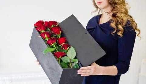 Man gives red roses in an original box to his beloved woman Stock Photos
