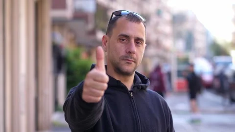 Man gives thumbs up with serious expression Stock Footage 308636103