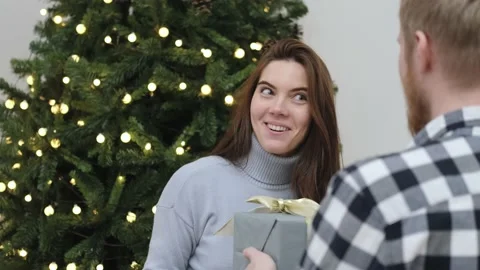 Man giving christmas gift box to smiling woman Stock Footage 155736853