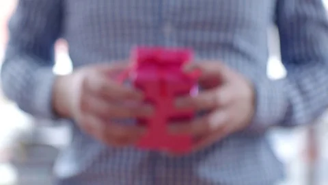 Man giving a gift in pink box with red ribbon Stock Footage 71615563