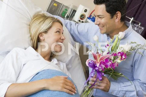 Man Giving His Pregnant Wife Flowers Stock-Fotos