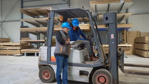 Man giving instructions to apprentice in warehouse, using cart Stock Footage 123163003