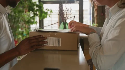 Man giving Parcel with Delivery Form to Woman Stock Footage 316599203