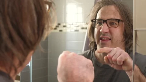 Man Giving a Pep Talk In Front Of Mirror Talking To Himself Stock Footage 146561437