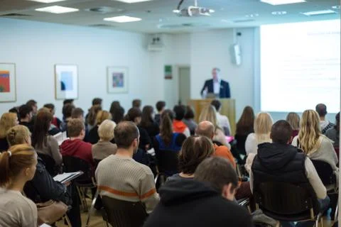 Man giving presentation in lecture hall at university. Stock Photos