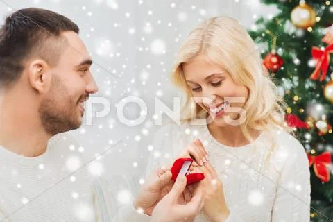 Man giving woman engagement ring for christmas Stock Photos