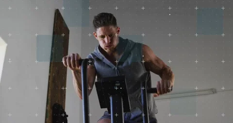 Man glancing at console, gripping handles and pedaling for cardio, overlay grid Vidéo 323431786