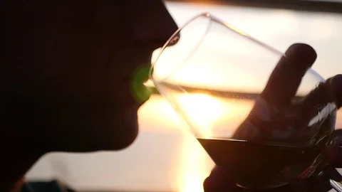 Man with a glass in his hands drinking wine at sunset, close-up. HD, 1920x1080 Stock Footage 79782097