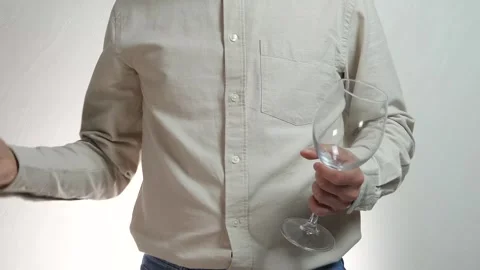 A man with a glass throws away a bottle of alcohol Stock Footage 310957641