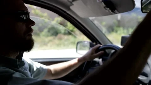 A man with glasses adjusts the rearview mirror, drives the car along the route Vídeo Stock 157632038