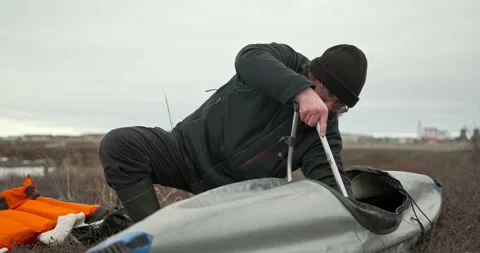 Man in glasses assembles kayak putting reinforcing elements Stock Footage 197059870