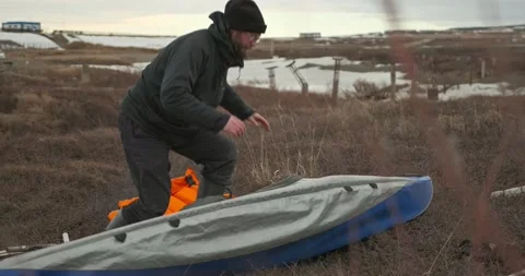 Man in glasses assembles kayak putting reinforcing elements Stock Footage 197059898