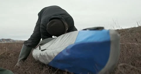 Man in glasses assembles kayak putting reinforcing elements Stock Footage 197059906
