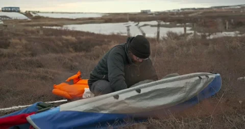 Man in glasses assembles kayak putting reinforcing elements Stock Footage 197059928