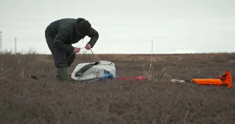 Man in glasses assembles kayak putting reinforcing elements Stock Footage 197059947