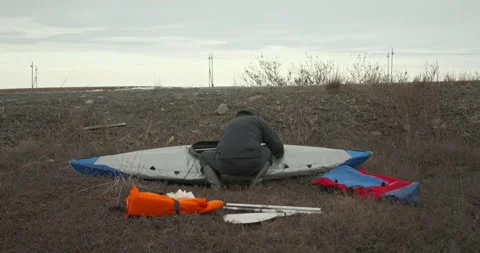 Man in glasses assembles kayak putting reinforcing elements Stock Footage 197059979