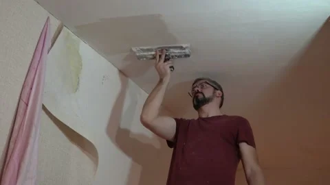Man with glasses covers the ceiling 4K Stock Footage 147894159