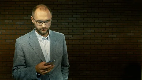A man in glasses dials text sms on a smartphone 07 Stock Footage 97566057
