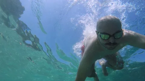 The man with glasses diving into the cool turquoise sea. Vídeo Stock 157831943