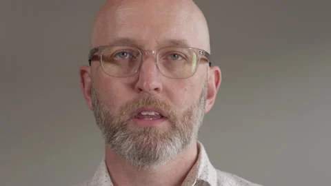 Man with glasses does a huge sneeze right at the camera in super slow motion Stockbeeldmateriaal 133300217