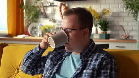 Man with glasses drinking coffee in the kitchen. 4k footage Stockbeeldmateriaal 161658162