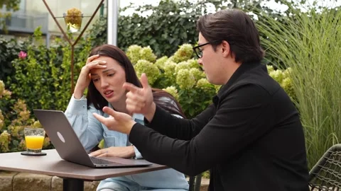 Man with glasses explains something to nervous girl, misunderstanding business Vidéo 253826505