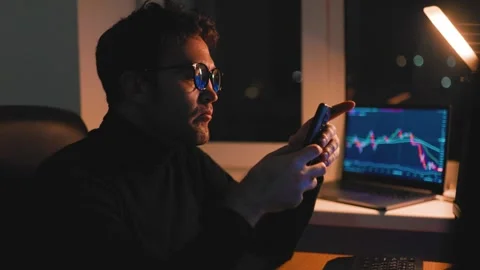 Man with glasses focused on smartphone while sitting in a dimly lit room Stock Footage 305149004