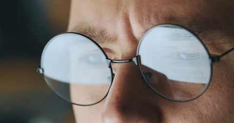 Man in glasses journalist looking at screen, reading english book, frowning Stock Footage 157836104