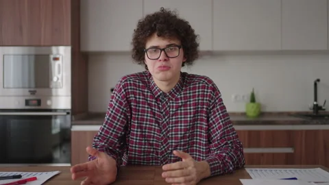 A man with glasses looking into the camera talks Stock Footage 182862178