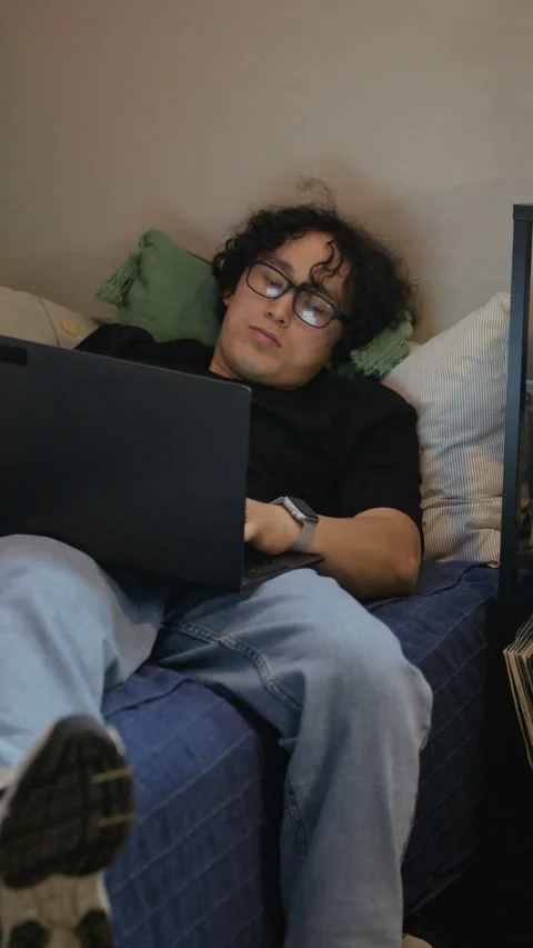 Man with Glasses Lying down Working on Laptop Stock Footage 338421757