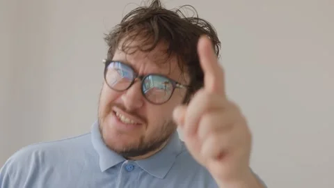 Man with glasses pointing up as if explaining an idea or solution 動画素材 325323175