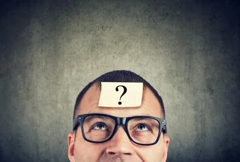 Man in glasses with question mark looking up Stock Photos