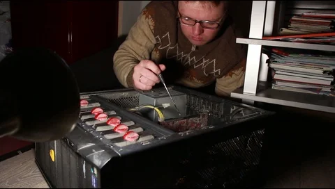 A man in glasses repairs a computer system unit Stock Footage 112520138
