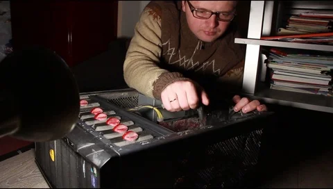 A man in glasses repairs a computer system unit Stockbeeldmateriaal 112520150