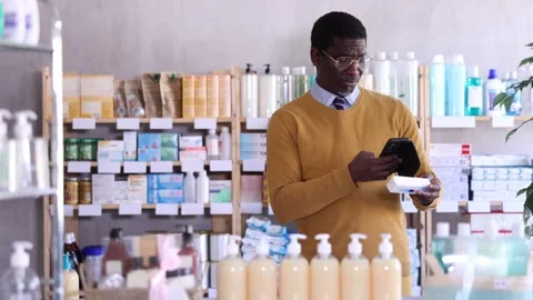 Man in glasses scans code on package of ointment to check the expiration date Stock Footage 317992722