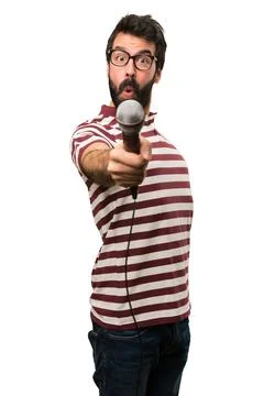 Man with glasses singing with microphone Stock Photos
