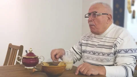 Man in glasses sits and drinks latte with cookies in cafe Stock Footage 147171694