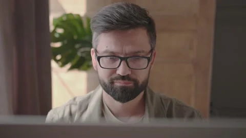 Man in glasses sitting at the computer up and running, shot from above Video stock 137232455