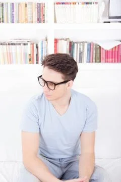 Man with glasses sitting on a couch Stock Photos